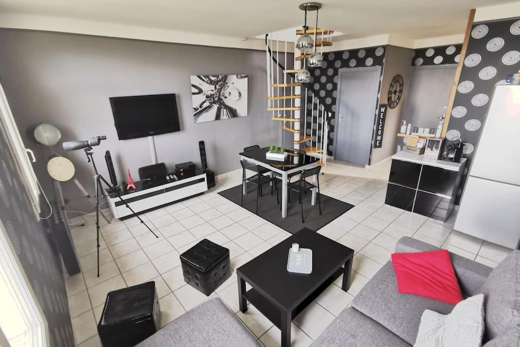 a living room with a couch and a tv at Duplex les pieds dans l'eau in Grandcamp-Maisy