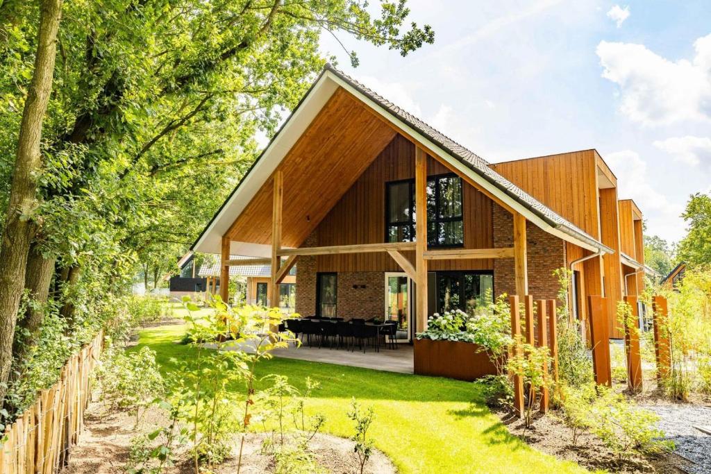 a home with a wooden house with a garden at Veluwe Villa met Binnenzwembad & Wellness - 12 personen - Resort Valley in Wekerom
