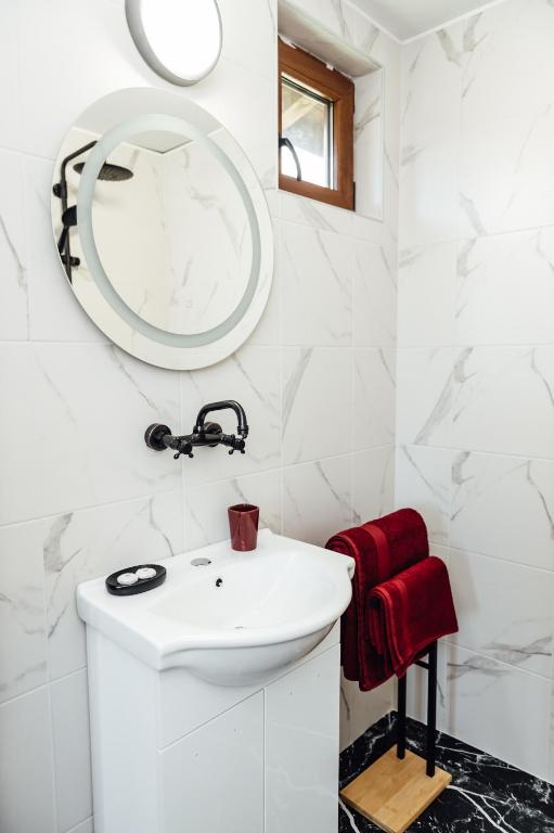 a bathroom with a white sink and a mirror at Къщи за гости БРИК in Sapareva Banya