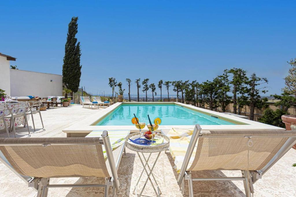 - une piscine avec 2 chaises et une table avec un vase dans l'établissement Villa Ardith by Villa Plus, à Raguse