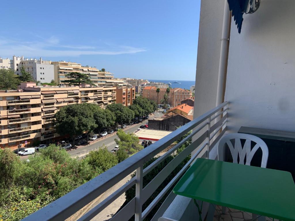 un balcone con un tavolo verde e una strada di T2 à proximité des plages a Cannes