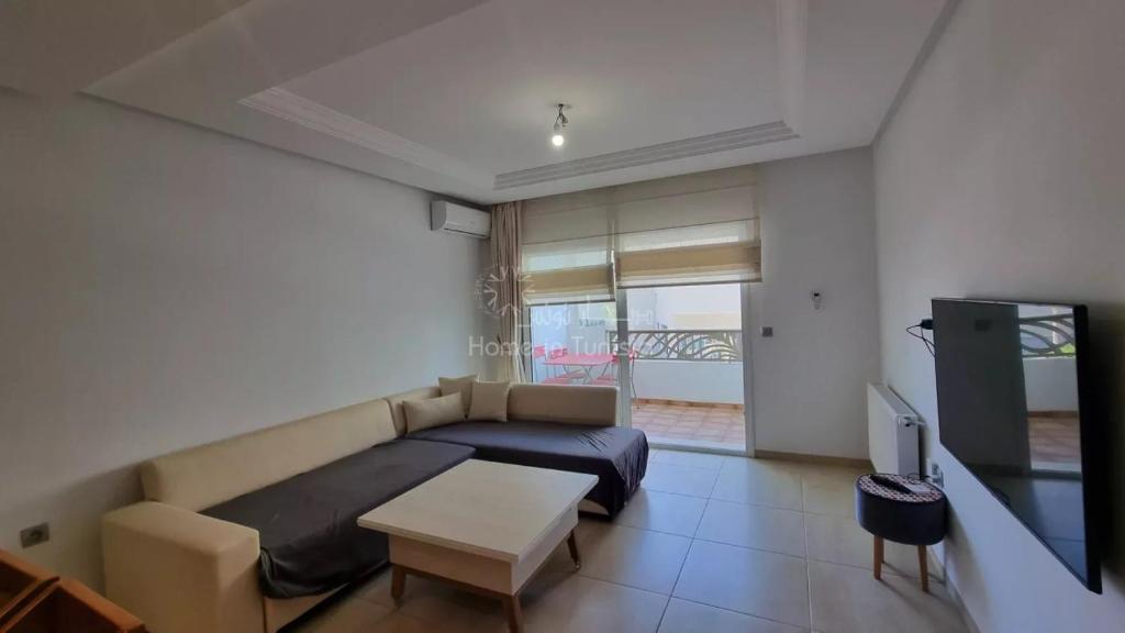 a living room with a bed and a tv at Location saisonniere Appartement Monastir in Sousse