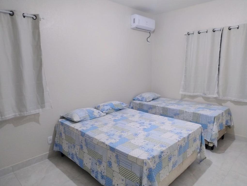 two twin beds in a room with white walls at Casa flor de Mandacaru in Piranhas
