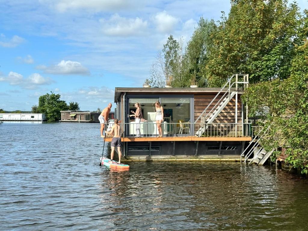 a house on a dock in the water at Houseboat PURE II in Vreeland