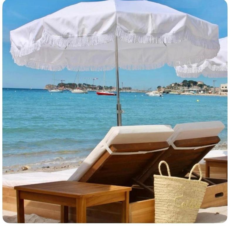 une chaise et un parasol sur la plage dans l'établissement Bandol-Plage EDEN ROC, à Bandol