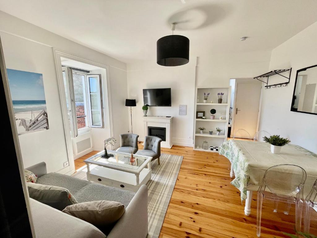 un salon avec un canapé et une table dans l'établissement En face de l'hôtel Normandy - Appartement dernier étage, à Deauville