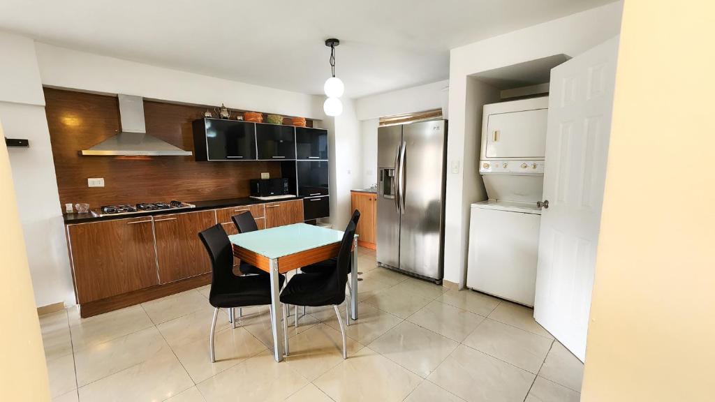 a kitchen with a table and chairs and a refrigerator at Acogedor apartamento en caracas in Caracas