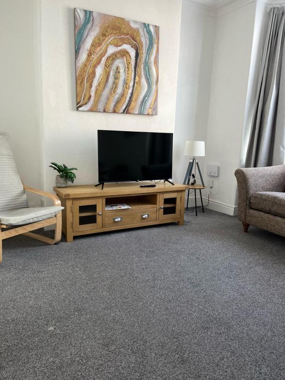 een woonkamer met een flatscreen-tv op een houten kast bij Lister House in Hartlepool