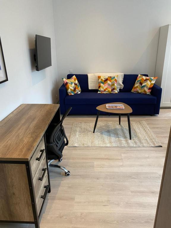 un salon avec un canapé bleu et une table dans l'établissement Marcq cocon, à Marcq-en-Barœul