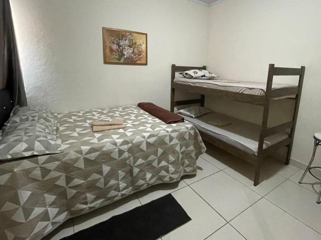 a small bedroom with a bed and a desk at Jockey Apto 2 in Campos dos Goytacazes
