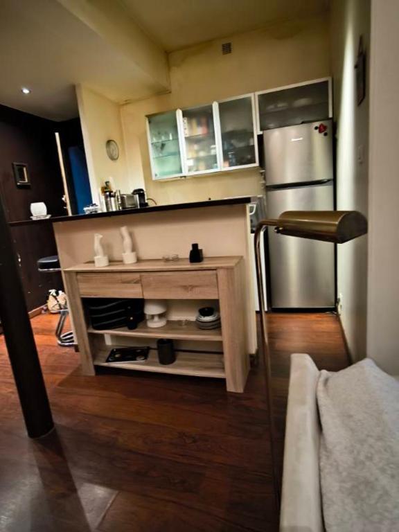 une cuisine avec un réfrigérateur en acier inoxydable et une table dans l'établissement Jardin Montoulieu, à Toulouse