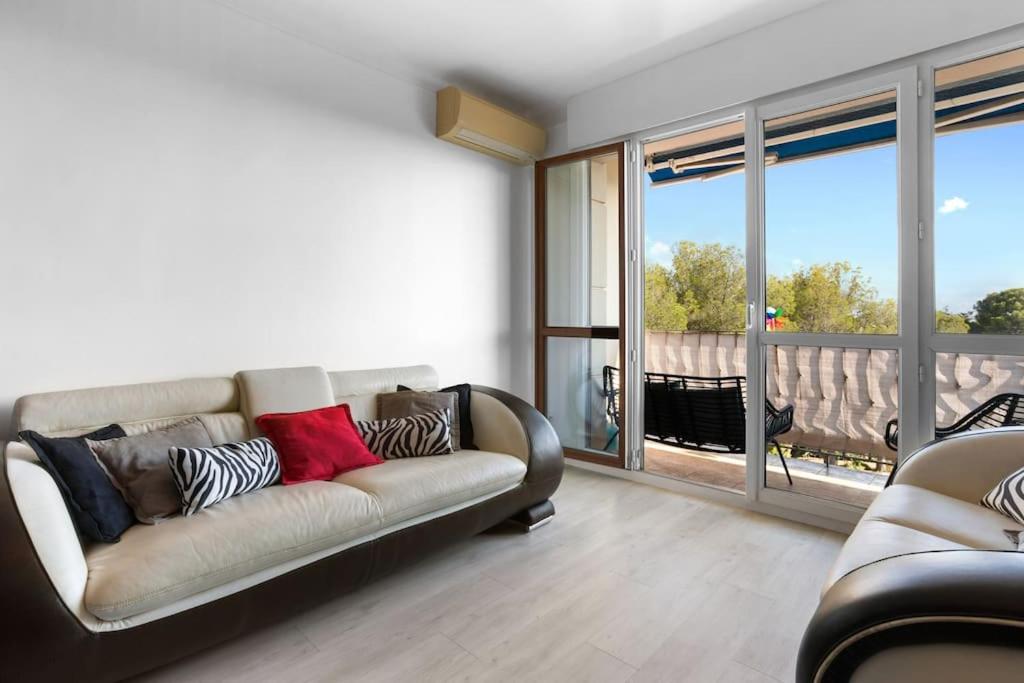 un salon avec un canapé et une grande fenêtre dans l'établissement Appart proche mer 5 min du centre, à Saint-Raphaël