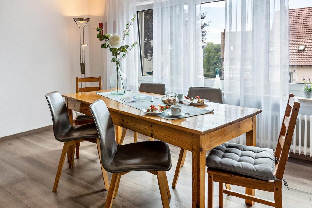 a dining room with a wooden table and chairs at Ferienwohnung Am Alten Brunnen in Gaienhofen