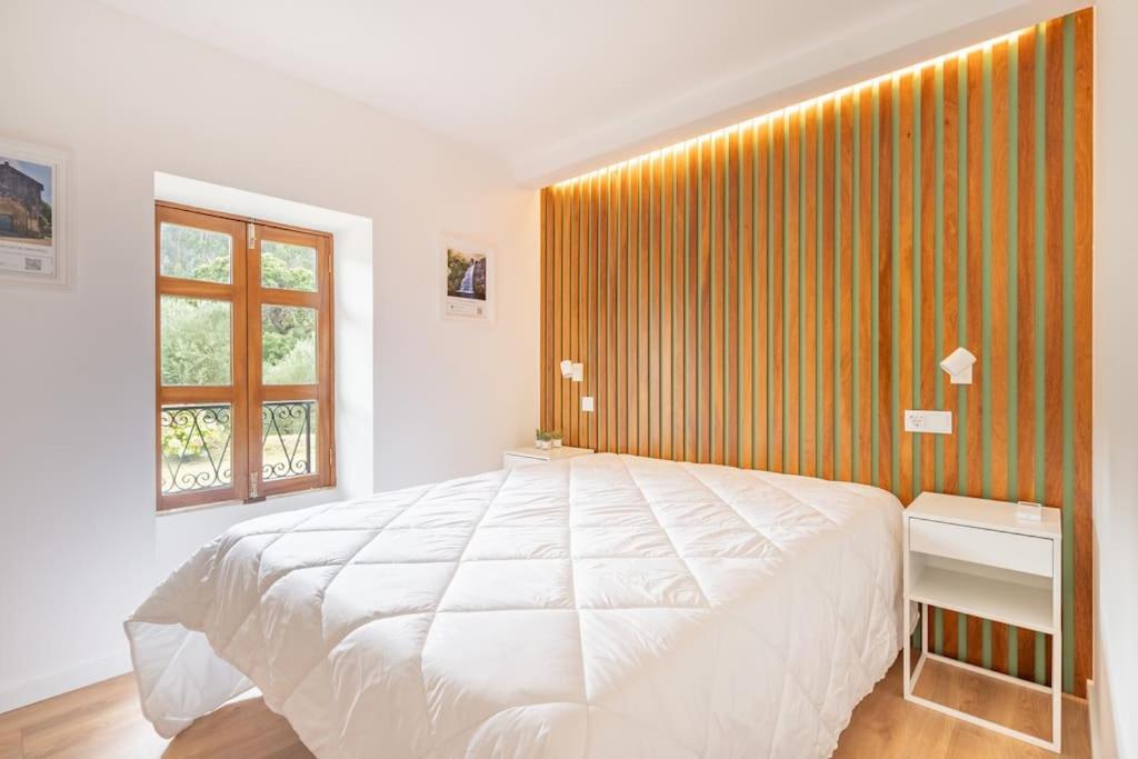 Segundo quarto com cabeceira em madeira ripada