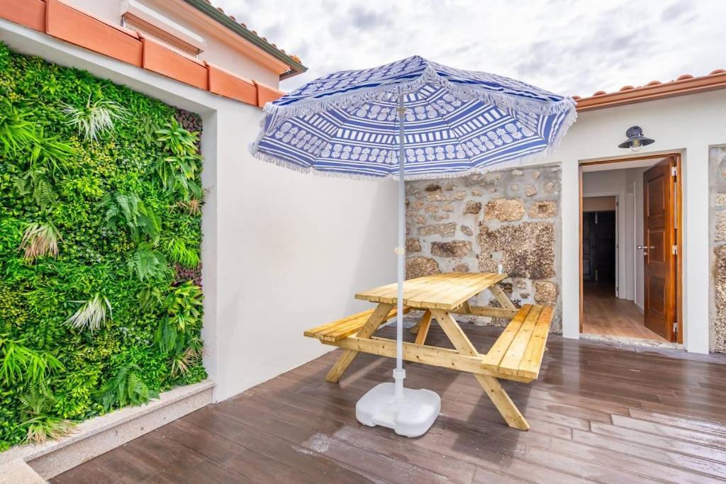 Pátio em pedra com mesa e chapéu de sol