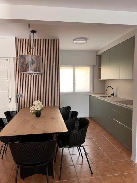 a kitchen with a wooden table and chairs in a room at ALMA de Bardenas in Arguedas