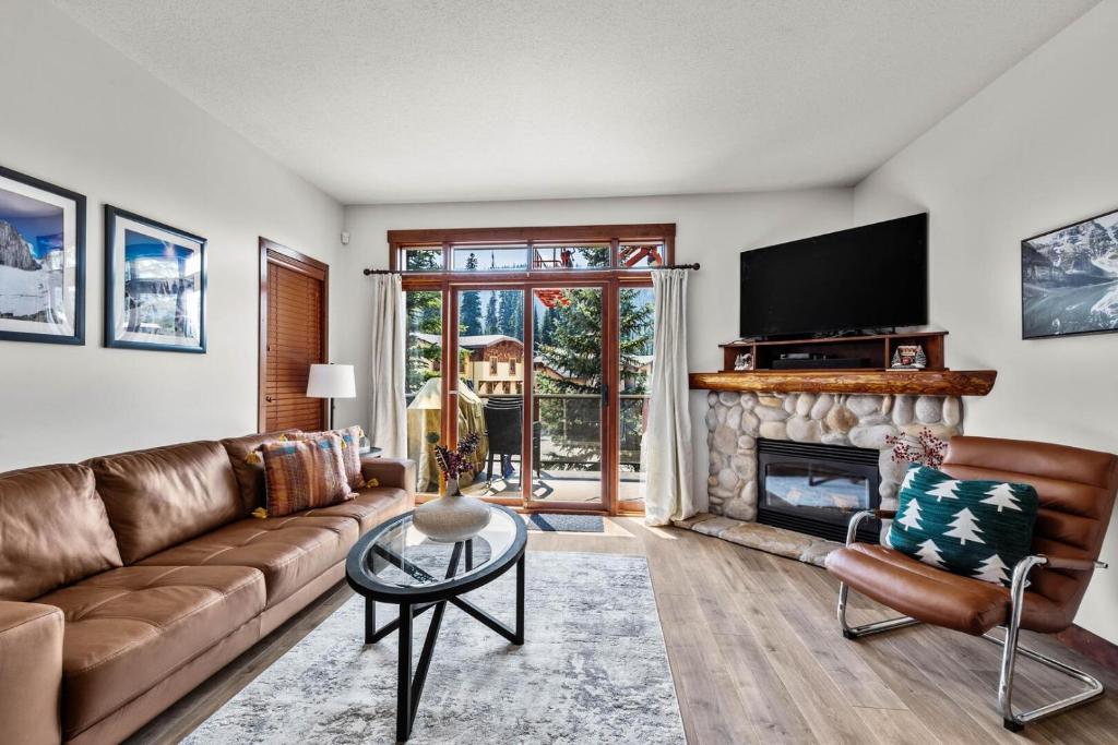 a living room with a couch and a fireplace at Trappers Landing #30 in Sun Peaks