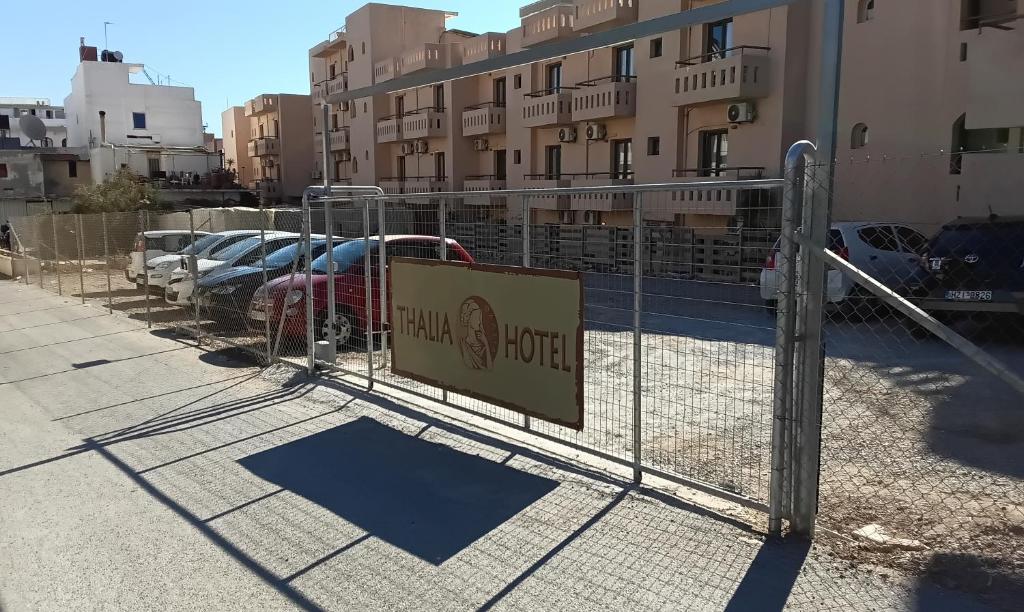a fence with a sign in front of a parking lot at Thalia deco City & Beach Hotel in Hersonissos