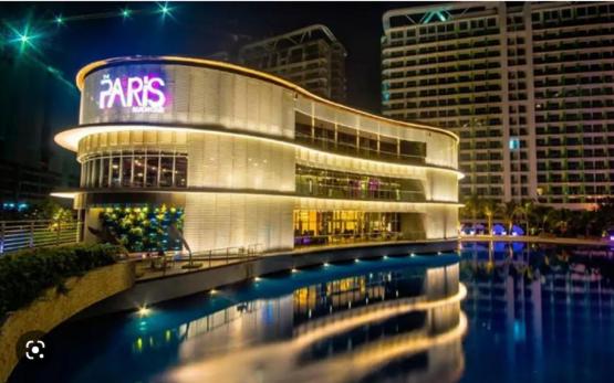 a large building with a reflection in the water at Manila Urban Resort at Azure in Manila