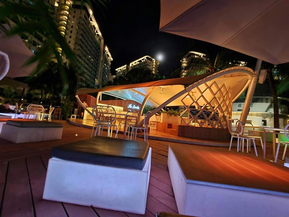 a patio with tables and chairs and an umbrella at Manila Urban Resort at Azure in Manila