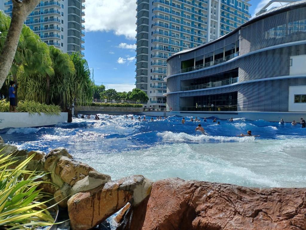 a lazy river in a city with people in the water at Manila Urban Resort at Azure in Manila