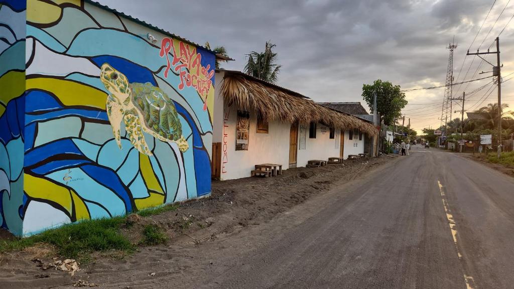 ein Wandbild an der Seite eines Gebäudes neben einer Straße in der Unterkunft Playa de la Fuente in El Paredón Buena Vista