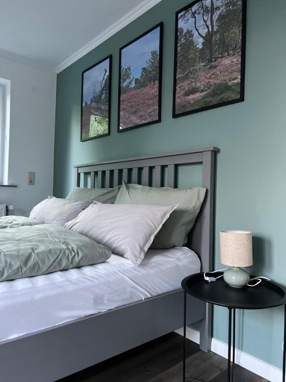 a bedroom with a bed with four pictures on the wall at Ferienwohnung am Pietzmoor in Schneverdingen