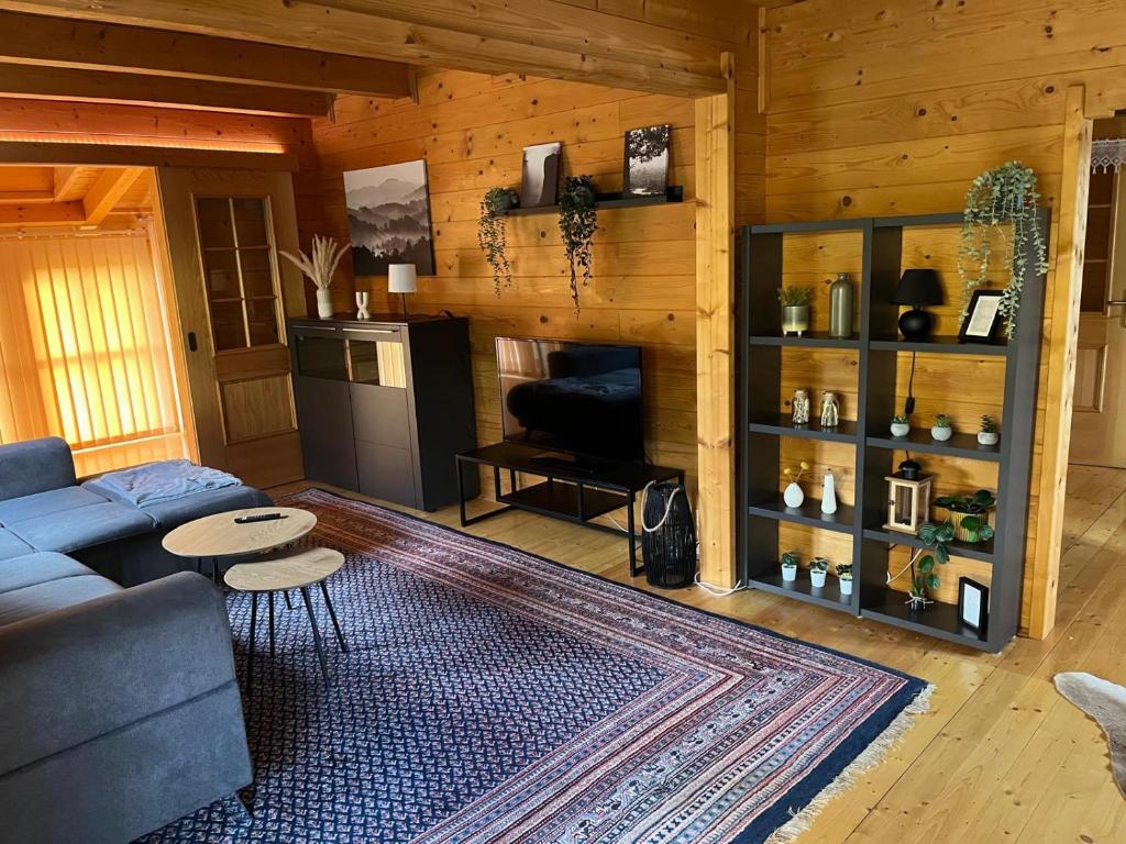 un salon avec un canapé bleu et une table dans l'établissement Großes gemütliches Chalet im Steigerwald nähe Bamberg, à Lisberg