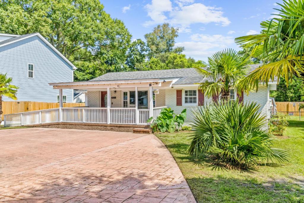 a house with a fence and palm trees at Charming 3-bedroom house in Wilmington with WiFi, AC in Wilmington