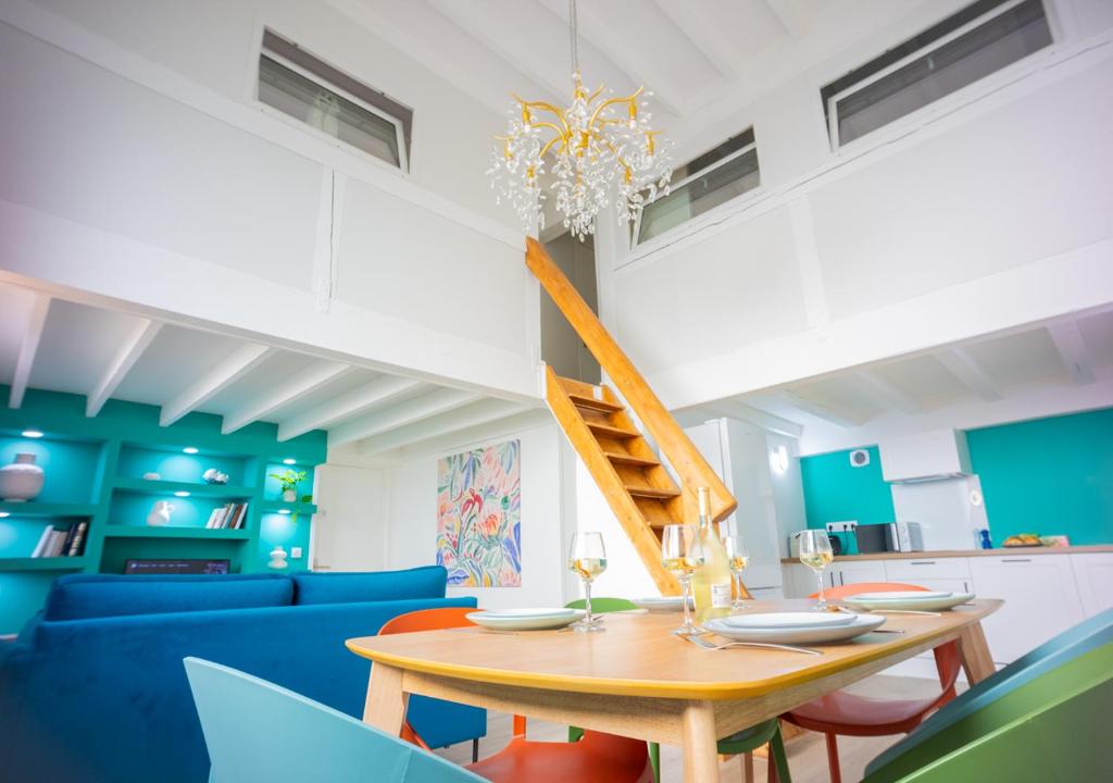 une salle à manger avec une table et un canapé bleu dans l'établissement DUPLEX 60m2 - MONTPELLIER PROCHE GARE, à Montpellier