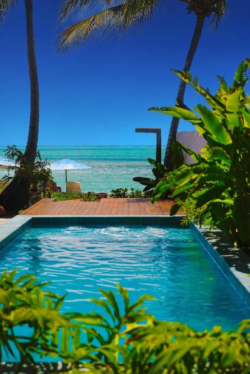 a swimming pool with the beach in the background at Pousada Rota Ecológica in Pôrto de Pedras