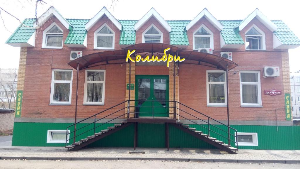 a blue and white building with a yellow door at Hotel Kolibri in Abakan