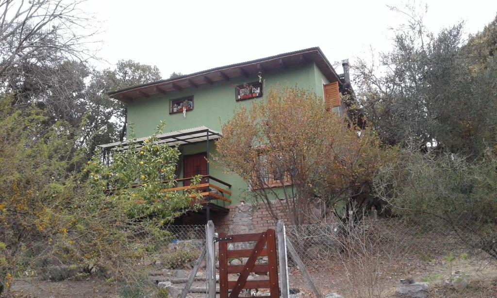 a green house with a fence in front of it at Habitacion serrana Stella Maris in Río Ceballos