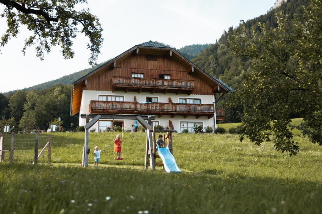 a group of children playing on a playground in front of a house at Urlaub am Dichtlhof in St. Wolfgang