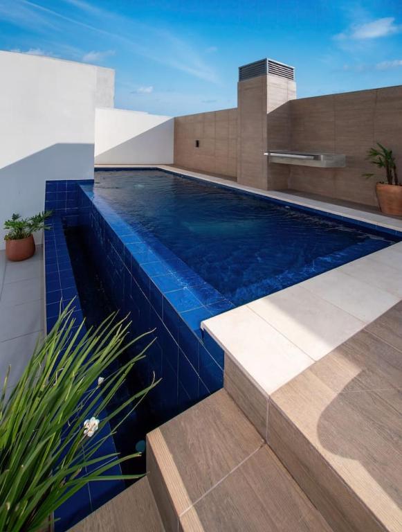 a swimming pool in a house with blue tiles at Stylish 2BR Apt in Top Location in Asunción