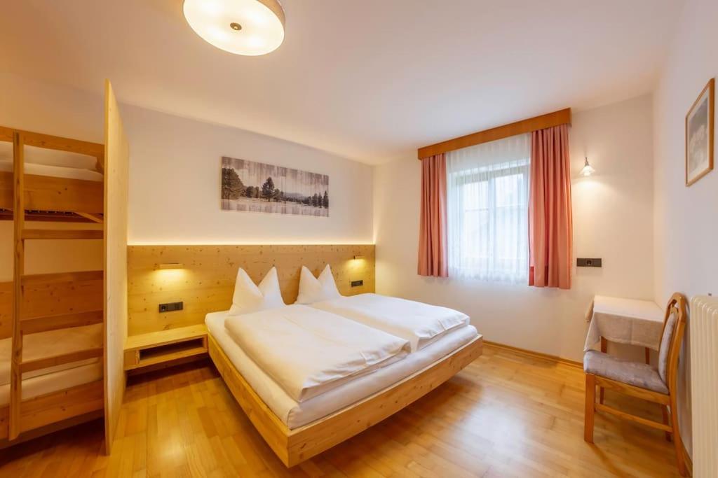 a bedroom with a large white bed and a ladder at Appartement Anger in Lutago