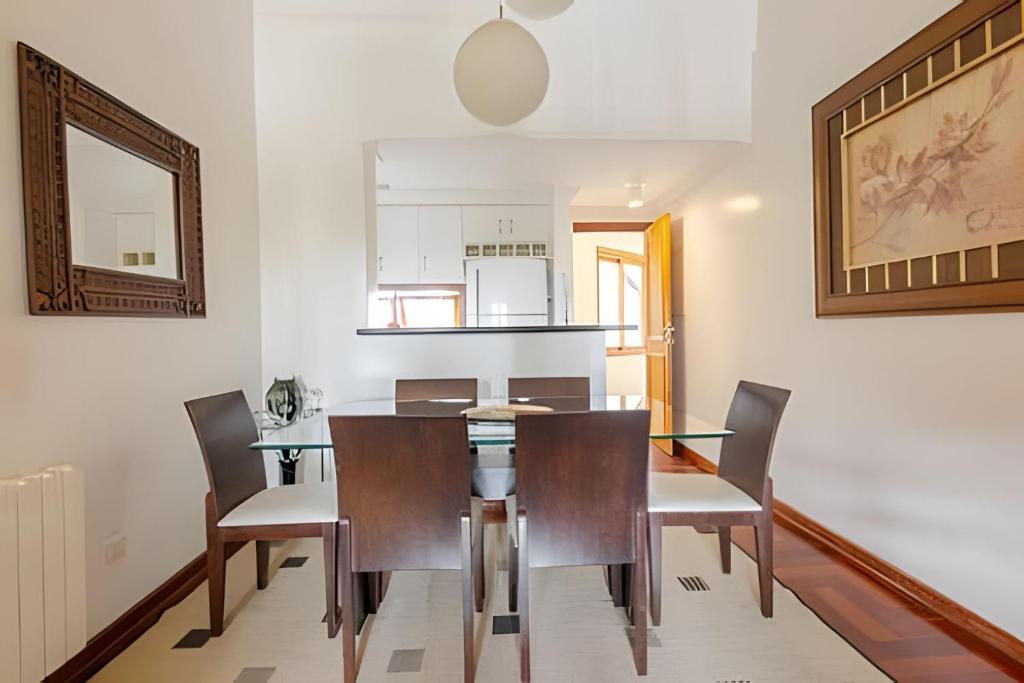 a dining room with a table and chairs at Apartamentos Centrinho Capivari - Recanto Boticário in Campos do Jordão