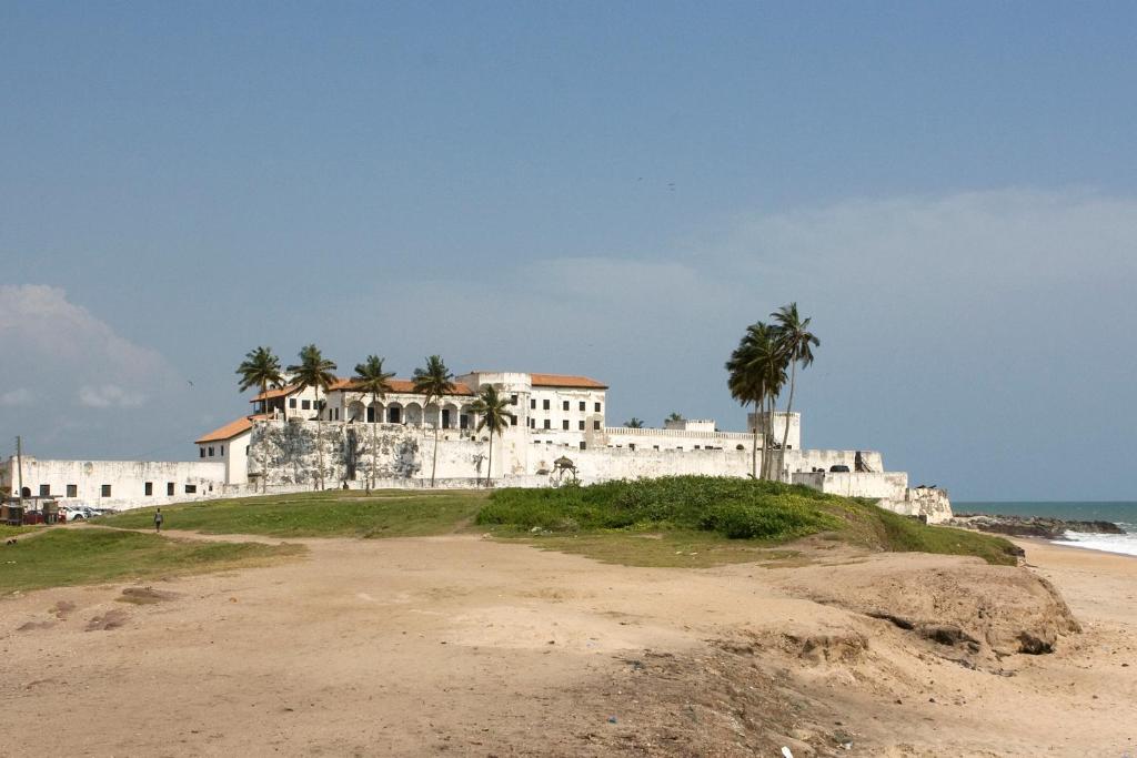 a large white building on a hill next to the beach at Purple Springs Elmina #1 in Esamang