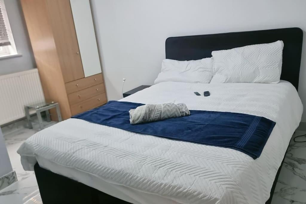 Entire-2 Bedroom Apartment with Driveway,1Free Parking في نوتينغهام: غرفة نوم بسرير وبطانية زرقاء وبيضاء
