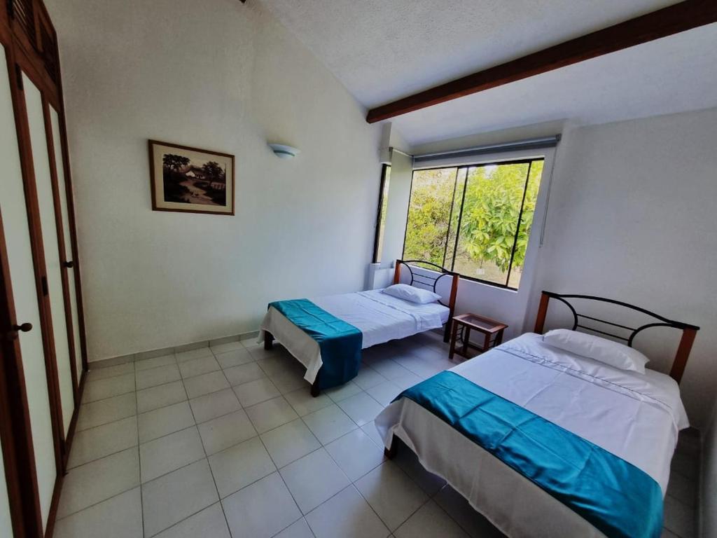 Un dormitorio con dos camas y una ventana. en Apartamento Melgar, Villa Flórez, en Melgar