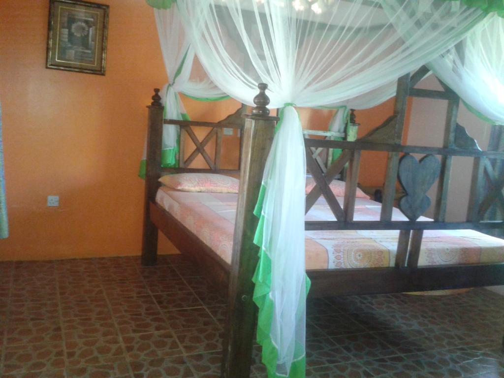 a bedroom with two bunk beds with curtains at Malaika Holiday Villas in Diani Beach