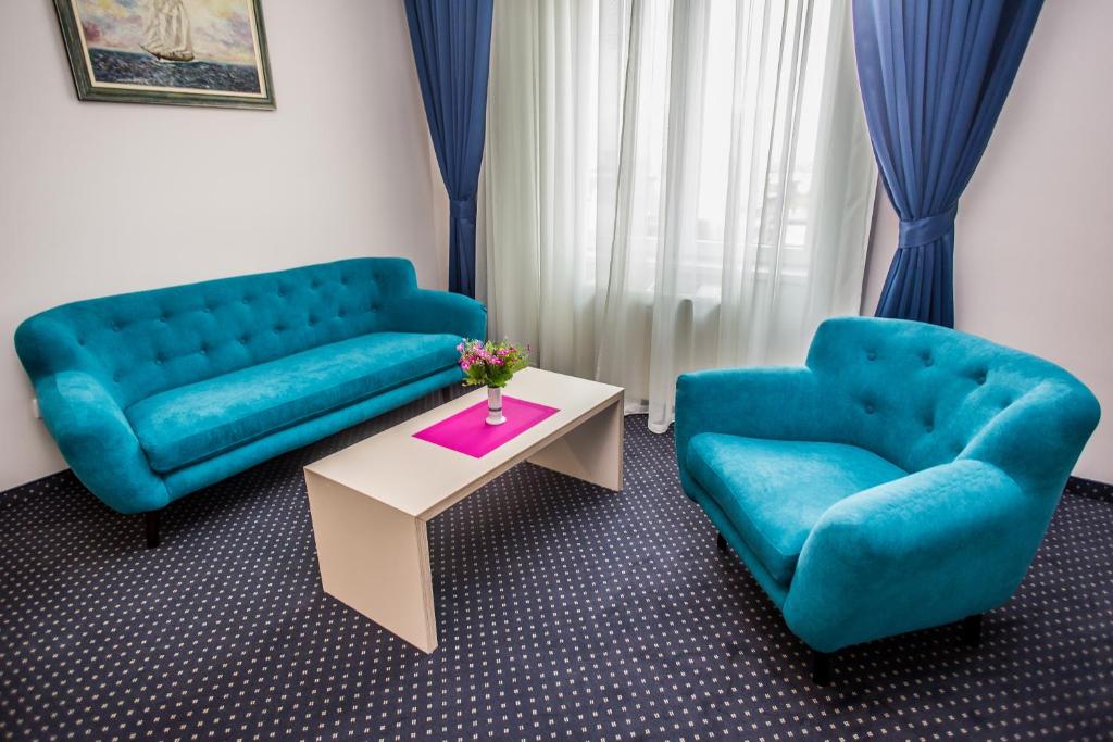 a living room with two blue couches and a table at Five Points Square - City Center in Belgrade