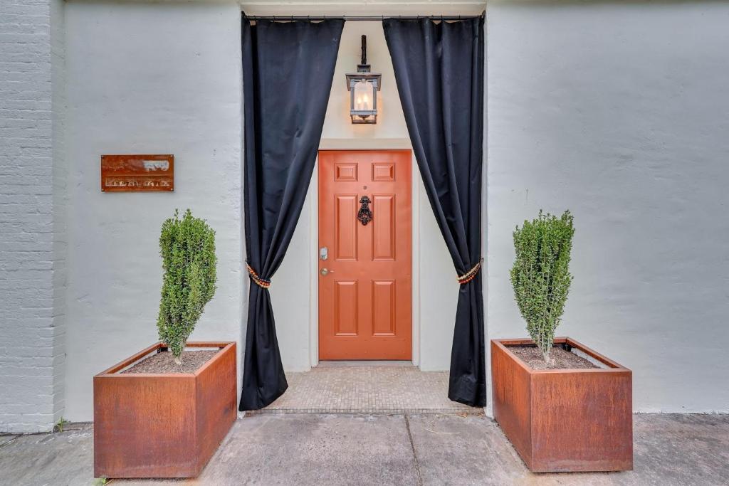 a red door with a black curtain and two plants at The Lincoln Loft, Near Forsyth Park with Free Parking in Savannah