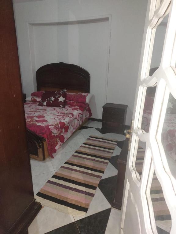ein Schlafzimmer mit einem Bett und einem Teppich auf dem Boden in der Unterkunft شقه مفروشة علي البحر عائلات فقط in Alexandria