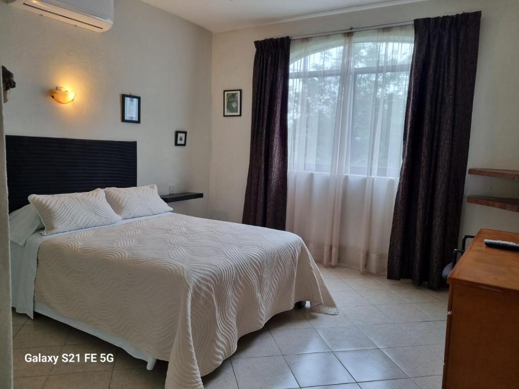 a bedroom with a bed and a large window at Delfin bnb in Cruz de Huanacaxtle