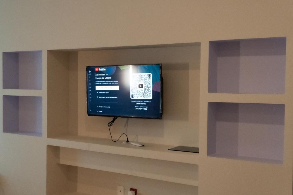 a flat screen tv in a wall at Infinity Suites Habitación Triple 212 in Cancún