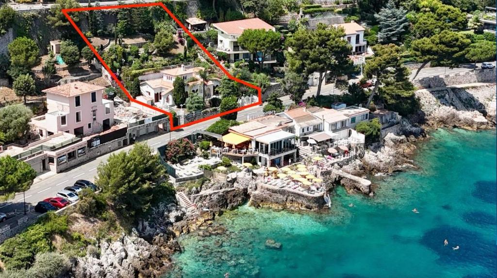 Vue aérienne d'une maison sur une île rocheuse dans l'eau dans l'établissement Villa CAP AZUR BORD DE MER, à Roquebrune-Cap-Martin