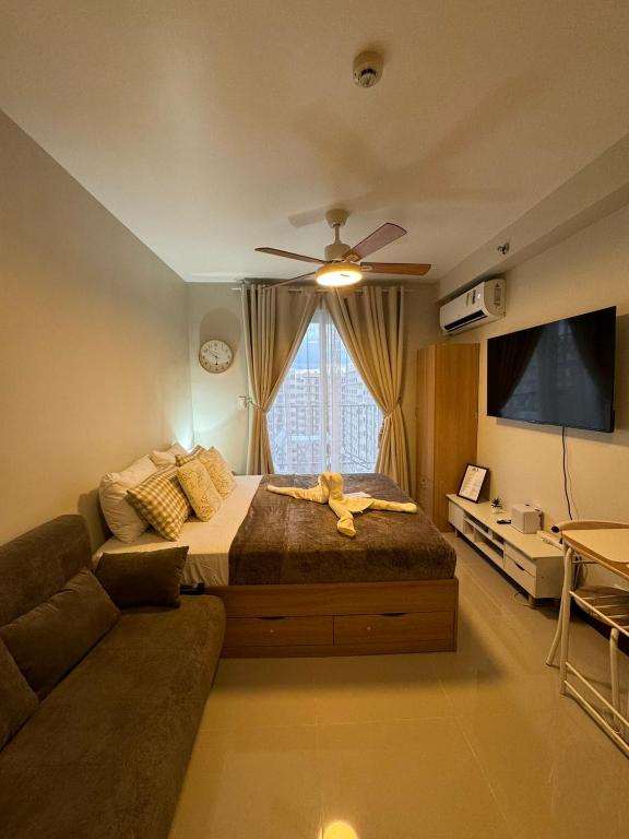 a bedroom with a large bed and a couch at AR's STAYCATION in Lapu Lapu City