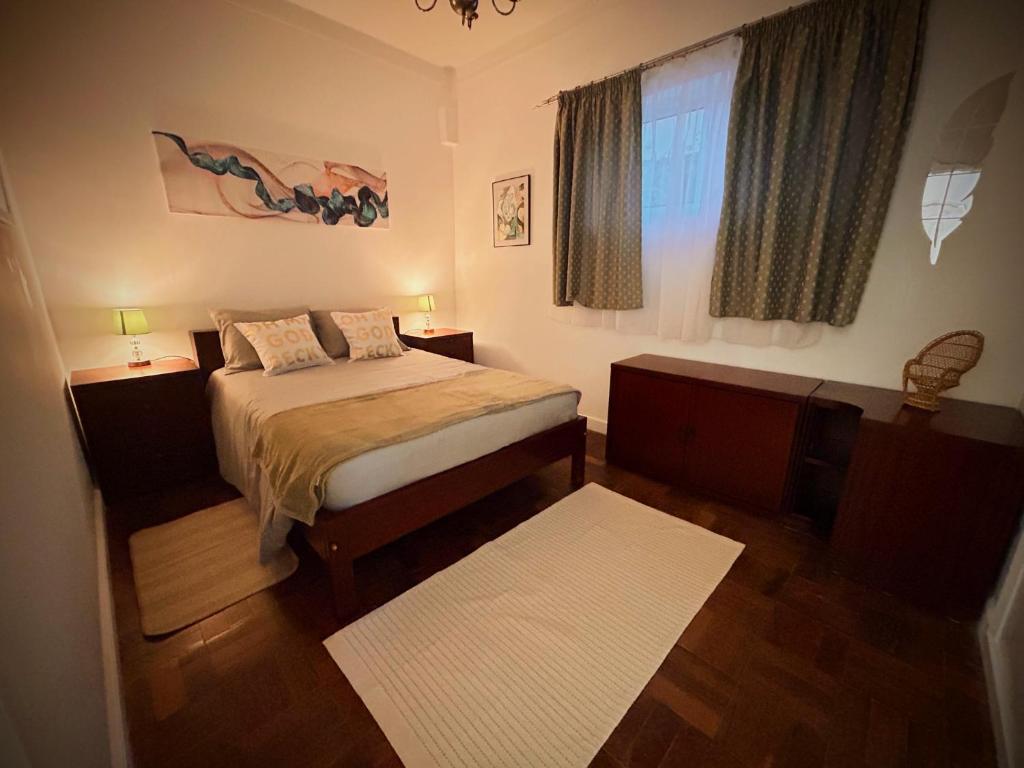a small bedroom with a bed and a window at Casinha Margarida in Adaúfe