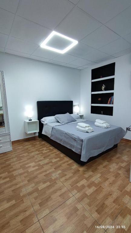a bedroom with a bed and a wooden floor at Estudio Santa Catarina in Málaga